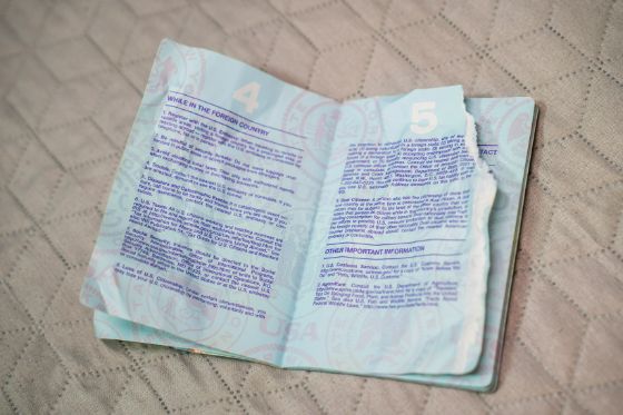 An damaged passport book laying open with a badly ripped page