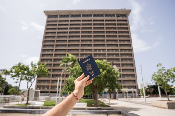 Puerto Rico Passport Center building entrance hand holding up a new passport